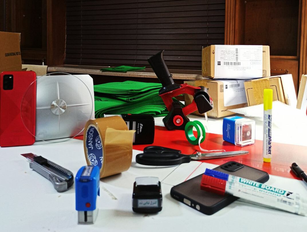 Filming equipment including camera, lenses and clapperboard laid out on a table